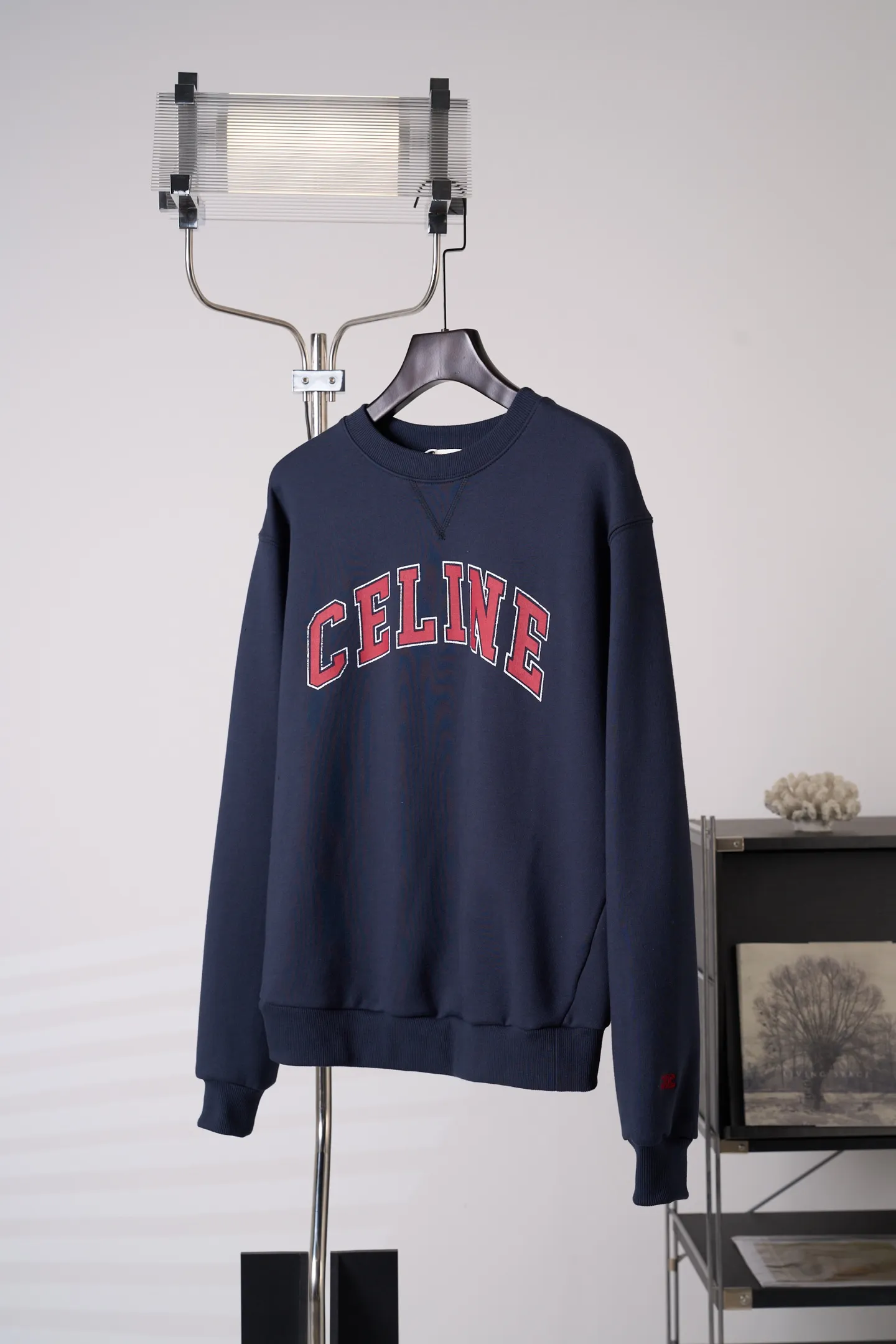[Real auction] Celine/Céline Paris letter printed logo round neck sweatshirt (women's style) [In Stock] S M L custom-dyed densely woven fish scale sheared cotton material, fine and fluffy, soft and skin-friendly. The navy blue base color settles the retro tone, and the burgundy contrasting color evokes the college charm, gently interpreting the casual and free girl's posture. The iconic Celine Paris arch print is placed on the chest of the body, and the Retro school font is layered in contrasting colors, which is neat, full and powerful; the cuffs are embellished with exquisite hand-embroidered logos, which are low-key and hidden in the sleeves, and the light and dark echo each other. The soft dropped shoulders and loose fit take into account relaxation and neat lines. The moderate length flatters the body shape and creates a casual retro college girl silhouette. The style is evident in the details, relaxed yet refined, interpreting the retro accent of contemporary girls. 1. Imported machine embroidery technology uses advanced computer control systems and precision mechanical components to precisely create the iconic TRIOMPHE logo embroidery, with smooth and delicate lines and a full sense of sophistication. 2. Glue printing: Use glue liquid paint to print patterns on the fabric, and bake the fabric to fix the printed pattern. 3. Fermentation washing treatment: The fabrics have been fermentation washing, which makes the hand feel and texture better, is not easy to deform, shrink, and fade, and maintains long-term beauty and loose fit.